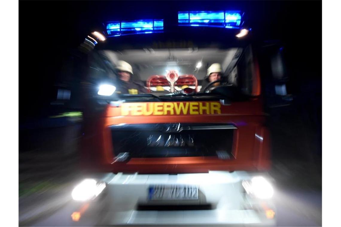 Männer der Feuerwehr sitzen in einem Löschfahrzeug. Foto: Carsten Rehder/Archiv