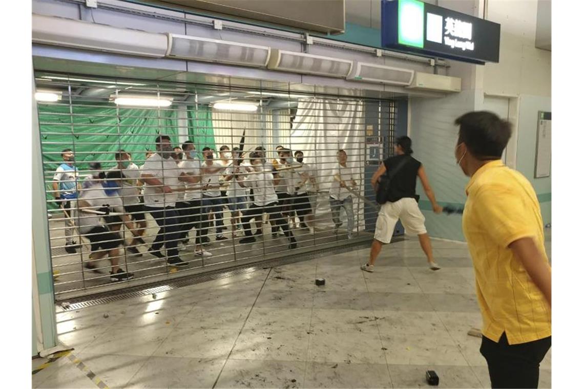 Hunderte Hongkonger protestieren am Airport gegen Regierung Männer in weißen T-Shirts mit Eisenstangen und Stöcken: 45 Menschen wurden am vergangenmen Wochenende bei Angriffen von Schlägertrupps zum Teil schwer verletzt. Foto: Apple Daily/AP