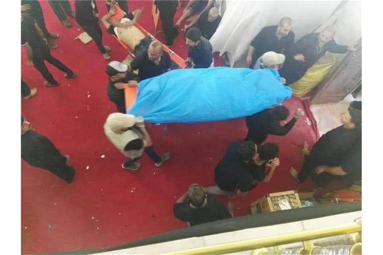 Männer tragen die Leiche eines bei der Massenpanik getöteten Gläubigen. Foto: XinHua