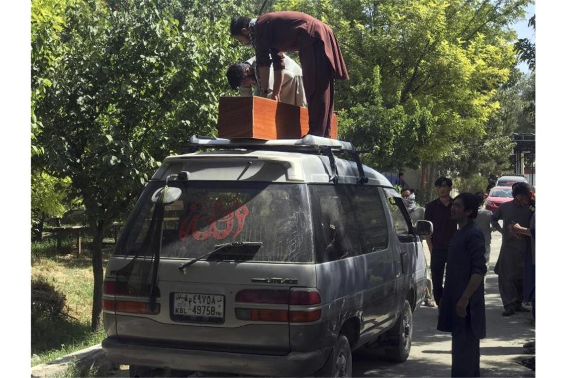 Nach Blutbad von Kabul: Biden kündigt Vergeltung an Männer transportieren in Kabul den Sarg eines Anschlagsopfers ab. Foto: AP/dpa