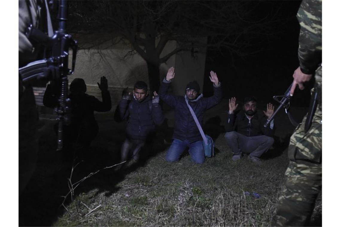 Männer werden von griechischen Soldaten festgenommen. Foto: Giannis Papanikos/AP/dpa