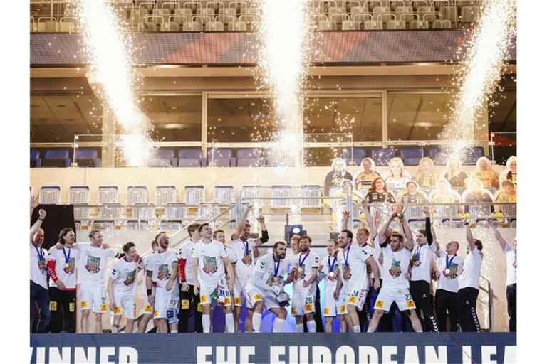 Magdeburgs Mannschaft feiert mit dem Siegerpokal den Finalsieg über die Füchse Berlin. Foto: Uwe Anspach/dpa