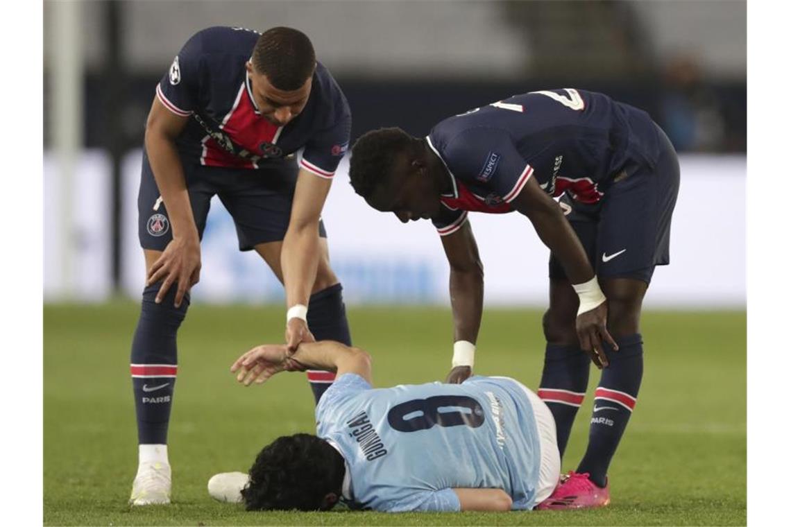 Manchester Citys Ilkay Gündogan (M) liegt nach einem Foul durch PSG-Spieler Idrissa Gueye (r) am Boden. Foto: Thibault Camus/AP/dpa