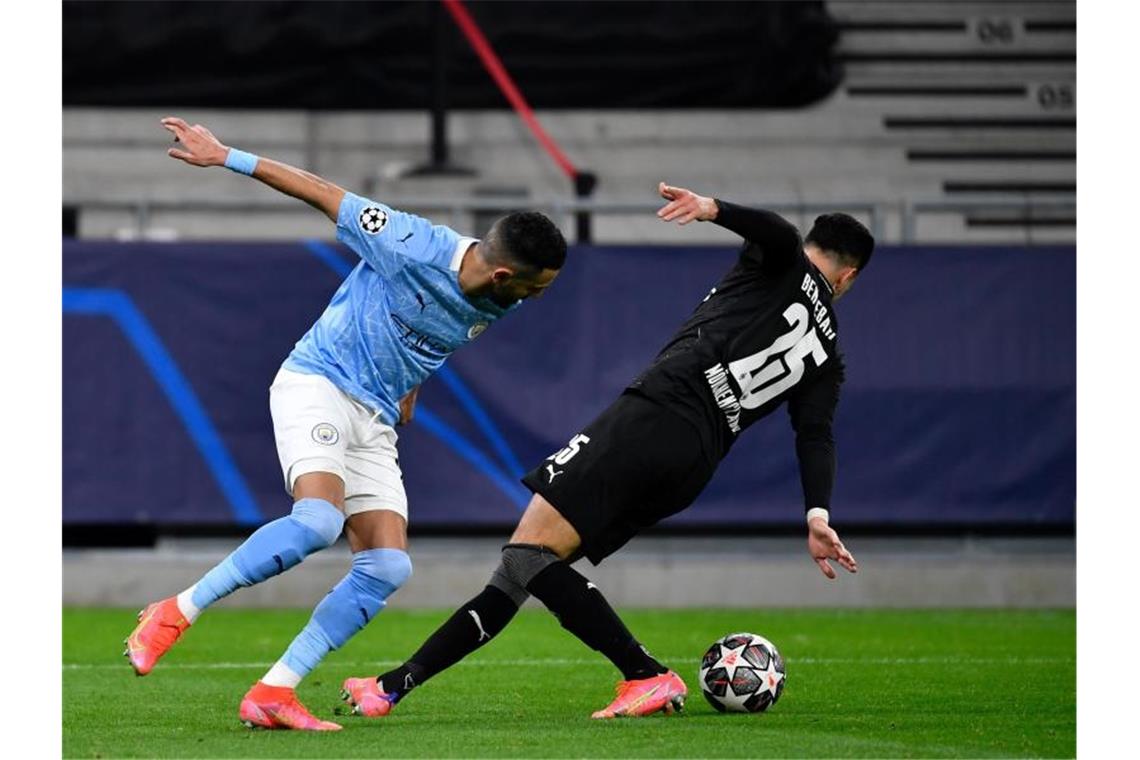Gladbach scheidet aus: „In der Summe sehr, sehr deutlich“ Manchester Citys Riyad Mahrez und Gladbachs Ramy Bensebaini (r) kämpfen um den Ball. Foto: Marton Monus/dpa