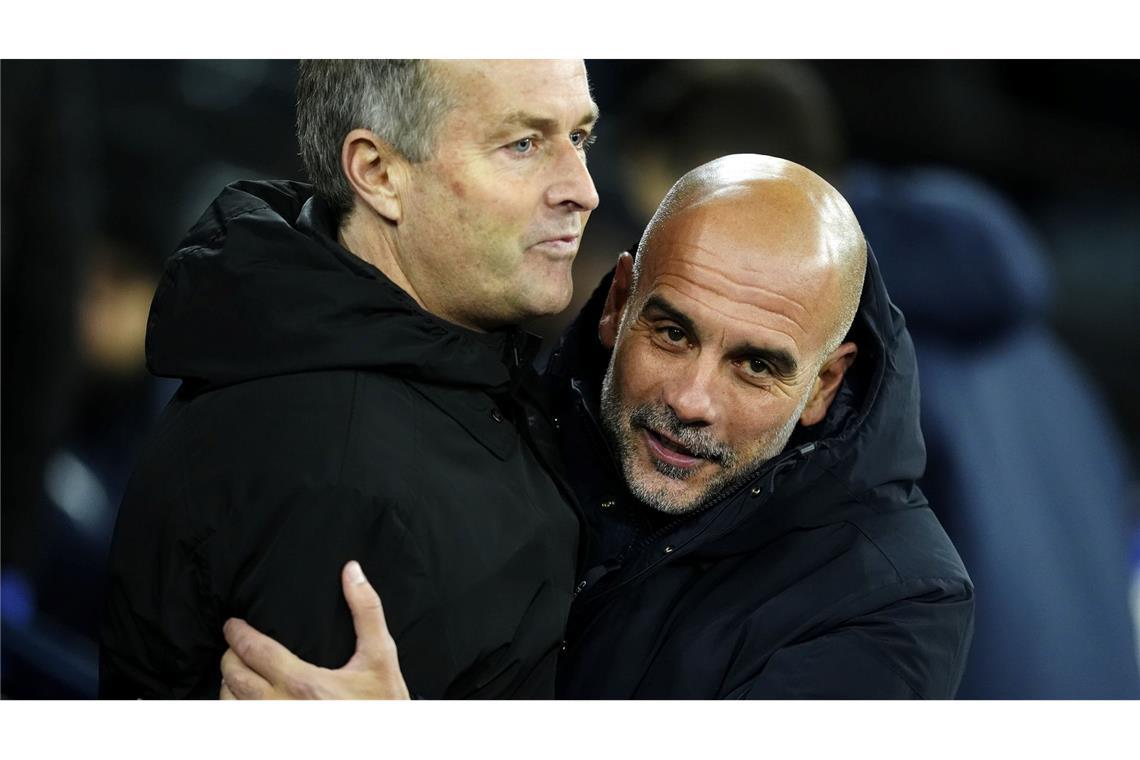 Manchester Citys Trainer Pep Guardiola (r) umarmt Bayer Leverkusens Cheftrainer Kasper Hjulmand vor dem Spiel.
