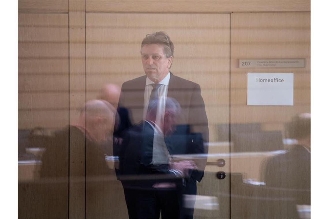 Manfred "Manne" Lucha steht vor einer Plenarsitzung des Landtags von Baden-Württemberg hinter einer Scheibe. Foto: Marijan Murat/dpa/Archivbild