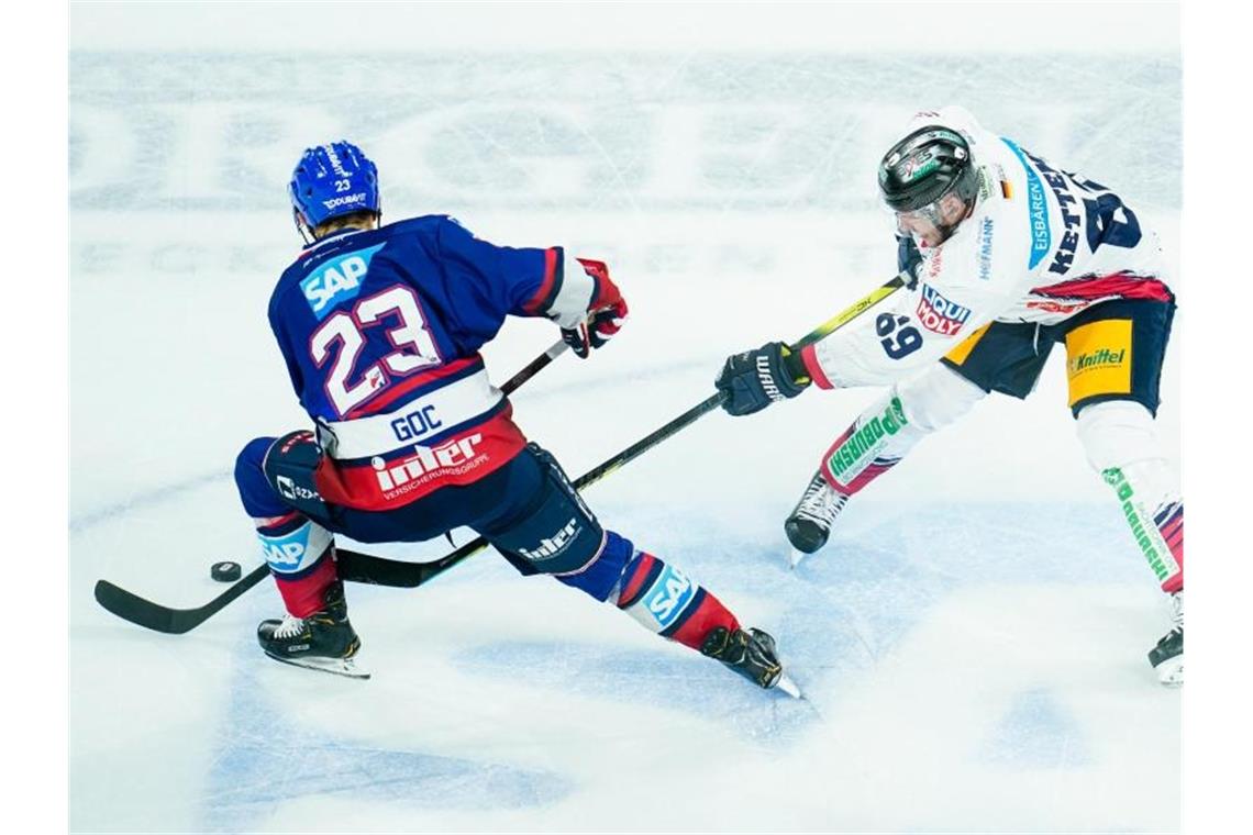 Mannheims Marcel Goc (l) und Berlins Florian Kettemer kämpfen um den Puck. Foto: Uwe Anspach/dpa/Archivbild