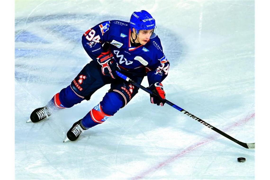 Mannheims Phil Hungerecker spielt den Puck. Foto: Uwe Anspach/dpa/Archivbild