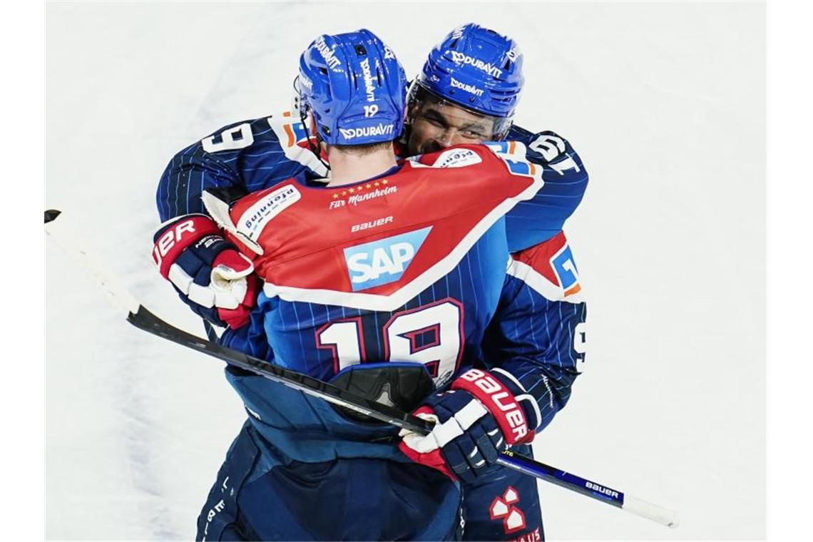 Corona prägt DEL: Mannheim besiegt München Mannheims Torschütze Nigel Dawes (r) jubelt über das Tor zum 3:2. Foto: Uwe Anspach/dpa