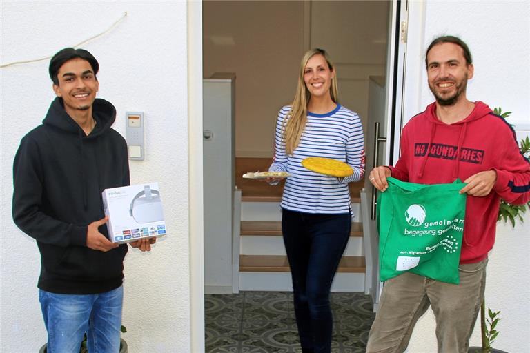 Mansour Niazi (aus Afghanistan) und Projektleiter Jochen Schneider (rechts) beliefern Jenny Wolf aus Weissach im Tal mit einer VR-Brille, frisch gebackenem afghanischen Brot sowie einer arabischen Süßspeise. Foto: privat