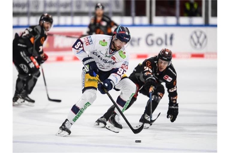 Marcel Noebels (l) von den Eisbären Berlin im Zweikampf mit Valentin Busch von den Grizzlys Wolfsburg. Foto: Swen Pförtner/dpa