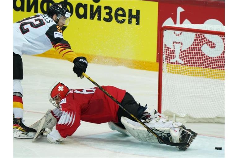 Marcel Noebels schießt den Puck am Schweizer Goalie Leonardo Genoni vorbei ins Tor. Foto: Roman Koksarov/dpa