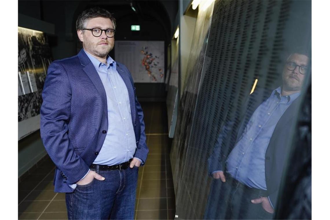 Team arbeitet an Datenbank zu KZ-Gefangenen Marco Brenneisen steht in der Gedenkstätte an einer Glaswand. Foto: Uwe Anspach/dpa/Archivbild