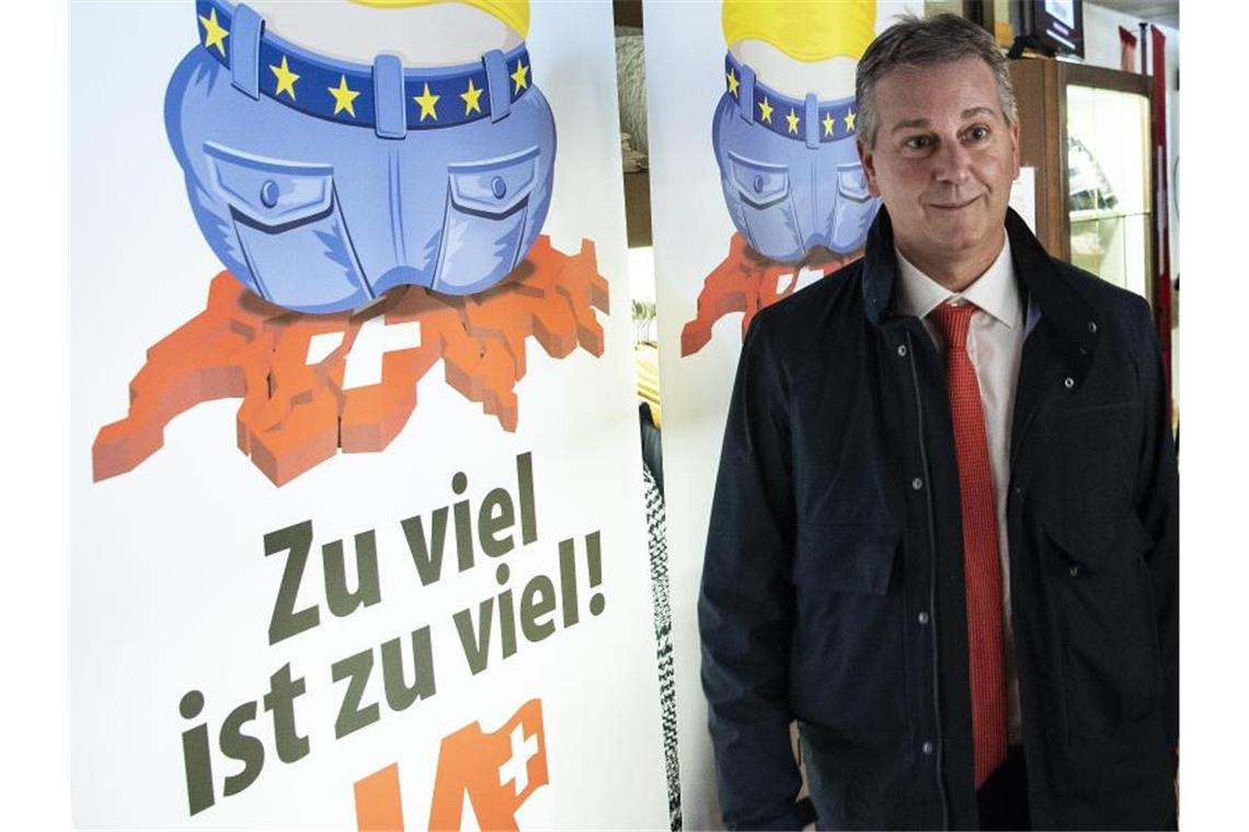 Marco Chiesa, Parteipräsident der rechten Schweizer Volkspartei SVP, steht 2020 neben einem Plakt, mit dem die Partei Stimmung gegen die EU machte. Foto: Peter Schneider/KEYSTONE/dpa
