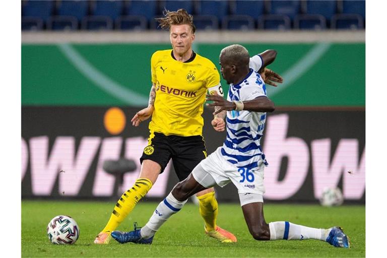 Marco Reus (l) von Borussia Dortmund und Wilson Kamavuaka vom MSV Duisburg kämpfen um den Ball. Foto: Marius Becker/dpa