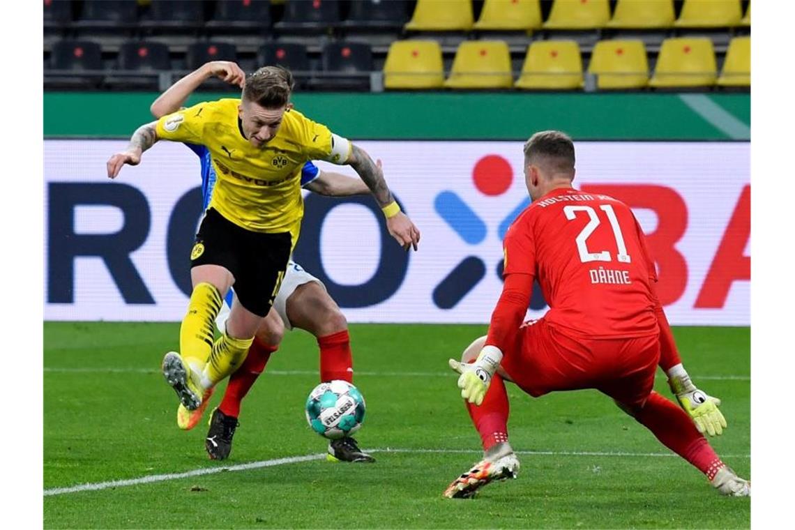 Marco Reus schießt im Fallen das Dortmunder 3:0. Foto: Martin Meissner/AP Pool/dpa