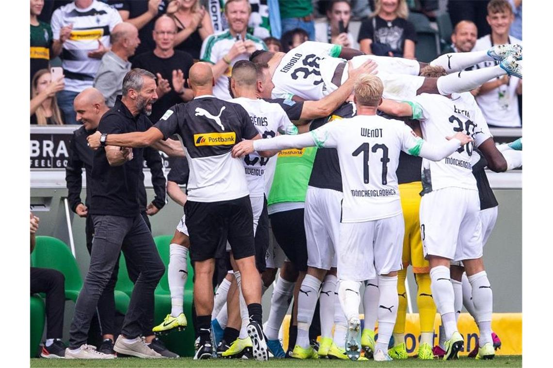 Marco Rose (2.v.l.) und seine Gladbacher bejubeln den Sieg gegen Düsseldorf. Foto: Marius Becker