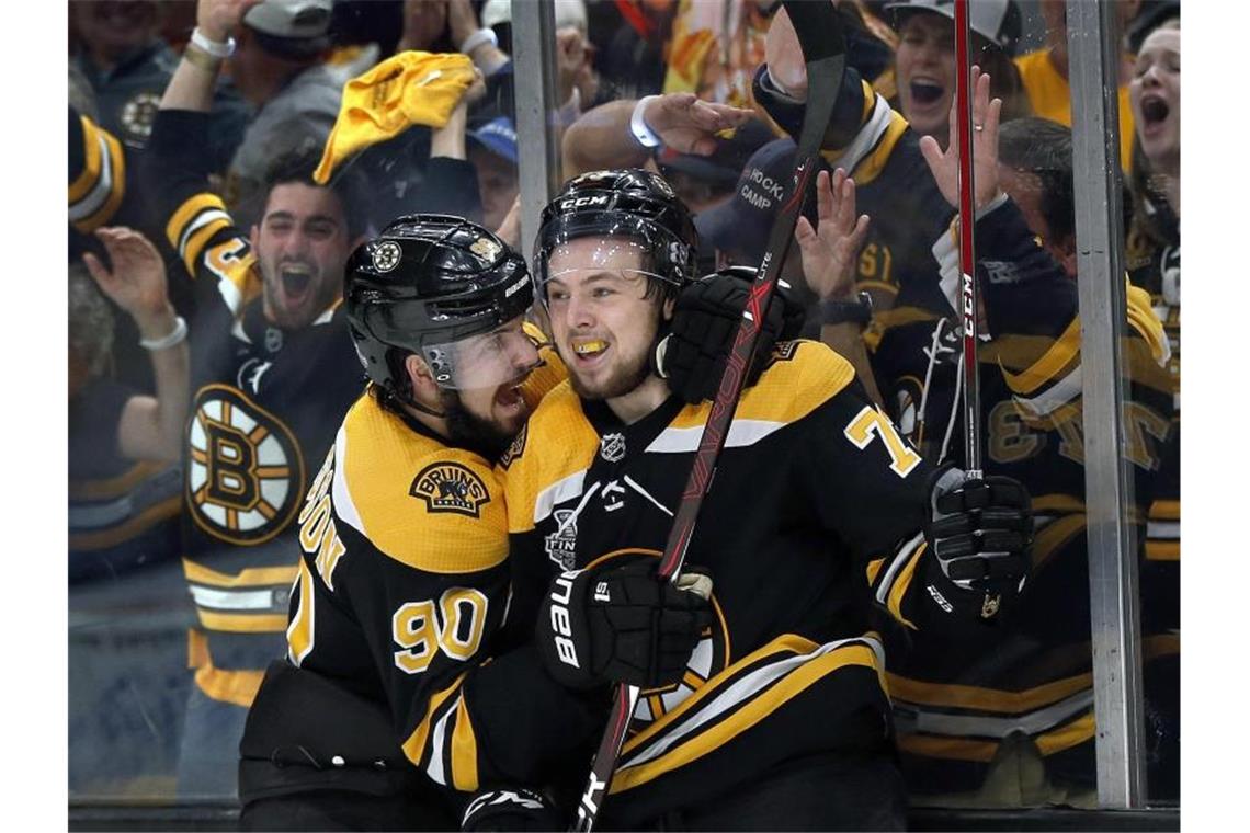 Marcus Johansson (l) und Charlie McAvoy von den Boston Bruins feiern den Sieg gegen die St. Louis Blues. Foto: Michael Dwyer/AP/dpa