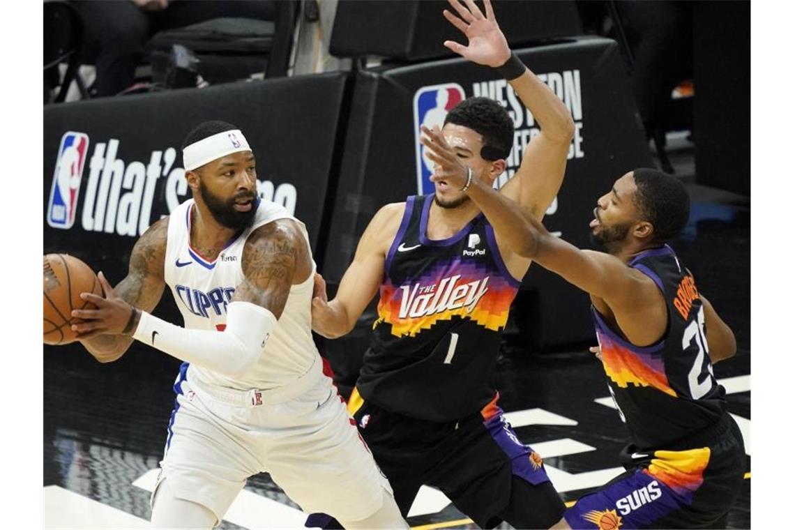 Marcus Morris Sr. wird von Devin Booker (M) und Mikal Bridges (r) verteidigt. Foto: Matt York/AP/dpa