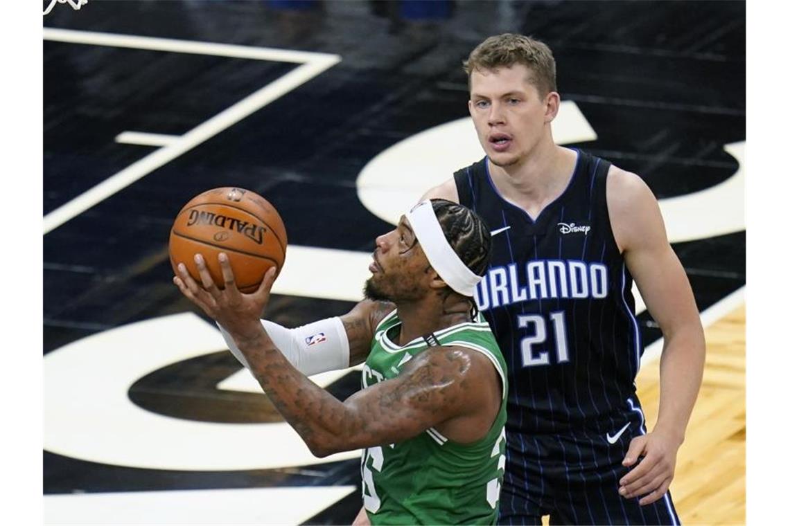 Marcus Smart (l) von den Boston Celtics setzt zum Wurf an. Moritz Wagner (21), Spieler bei Orlando Magic, versucht ihn zu decken. Foto: John Raoux/AP/dpa