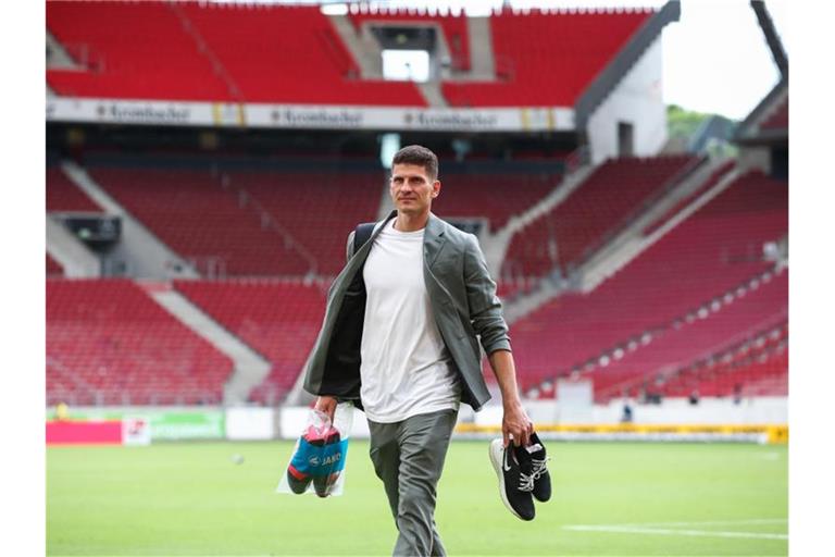 Mario Gomez läuft mit dem Schuhen in der Hand über den Platz. Foto: Tom Weller/dpa/Archivbild