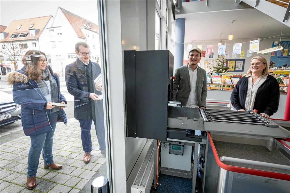 Quantensprung für die Stadtbücherei Backnang Marion Busch und Maximilian Friedrich testen die neue Außenrückgabe der Bücherei Backnang. Ihre entliehenen Bücher werden sekundenschnell nach innen zu Johannes Ellrott und Kerstin Drösler transportiert. Fotos: Alexander Becher