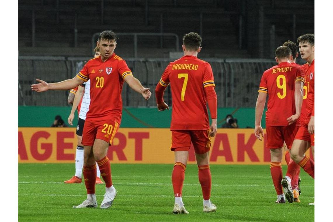 Mark Harris (l) klatscht mit Nathan Broadhead nach seinem Anschlusstreffer zum 2:1 für Wales ab. Foto: Swen Pförtner/dpa