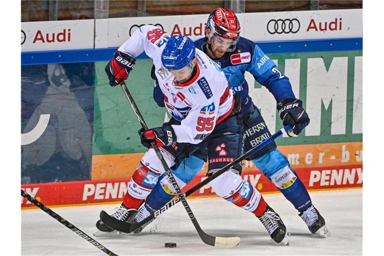 Mark Katic von Mannheim und Garret Pruden von Ingolstadt (l-r.) kämpfen um den Puck. Foto: Armin Weigel/dpa