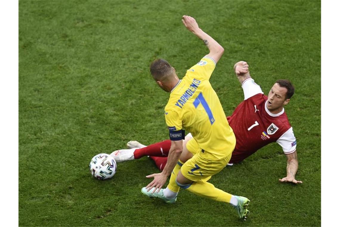 Marko Arnautovic (r) aus Österreichs und der Ukrainer Andrej Jarmolenko kämpfen um den Ball. Foto: Mihai Barbu/Pool AFP/AP/dpa