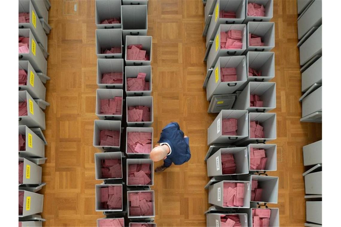 Markus Blocher, Kreiswahlleiter, begutachtet in einer Wahlbehörde zahlreiche Wahlurnen gefüllt mit Stimmzettelumschlägen für die Briefwahl. Foto: Sebastian Kahnert/dpa-Zentralbild/dpa