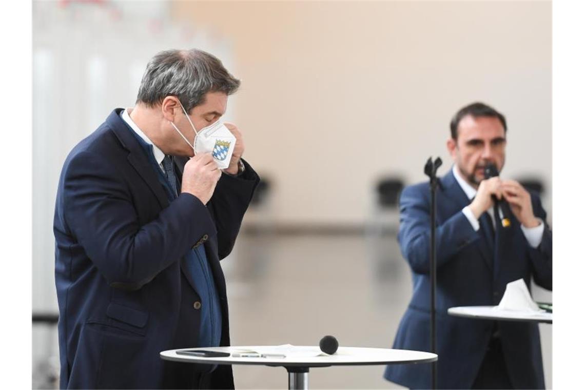 Markus Söder (CSU, l), bayerischer Ministerpräsident, bei der Besichtigung des neu eingerichteten Impfzentrums in der Messe München. Neben ihm spricht Klaus Holetschek, bisher Gesundheitsstaatssekretär, nun neuer Gesundheitsminister. Foto: Tobias Hase/dpa