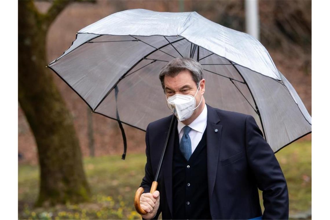Bayern bekennt sich zu Teil-Impfpflicht Markus Söder (CSU), Ministerpräsident von Bayern, kommt unter einem Regenschirm zur Pressekonferenz nach der Kabinettssitzung. Foto: Sven Hoppe/dpa
