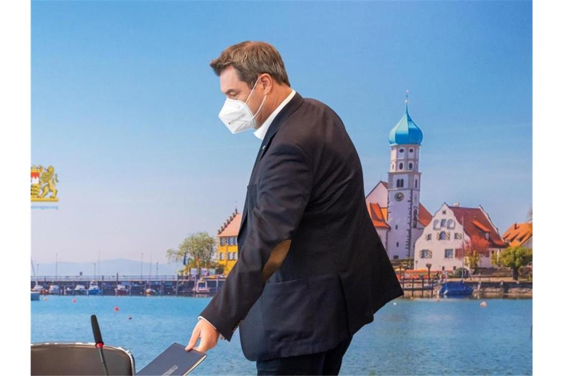 Markus Söder (CSU), Ministerpräsident von Bayern, nimmt vor Beginn der Sitzung des bayerischen Kabinetts, die als Videokonferenz geführt wird, seinen Platz vor einer Fototapete ein. Foto: Peter Kneffel/dpa