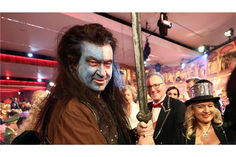 Markus Söder (l, CSU), Ministerpräsident von Bayern, nimmt als „Braveheart“ an der BR-Livesendung „Fastnacht in Franken“ in den Mainfrankensälen teil.