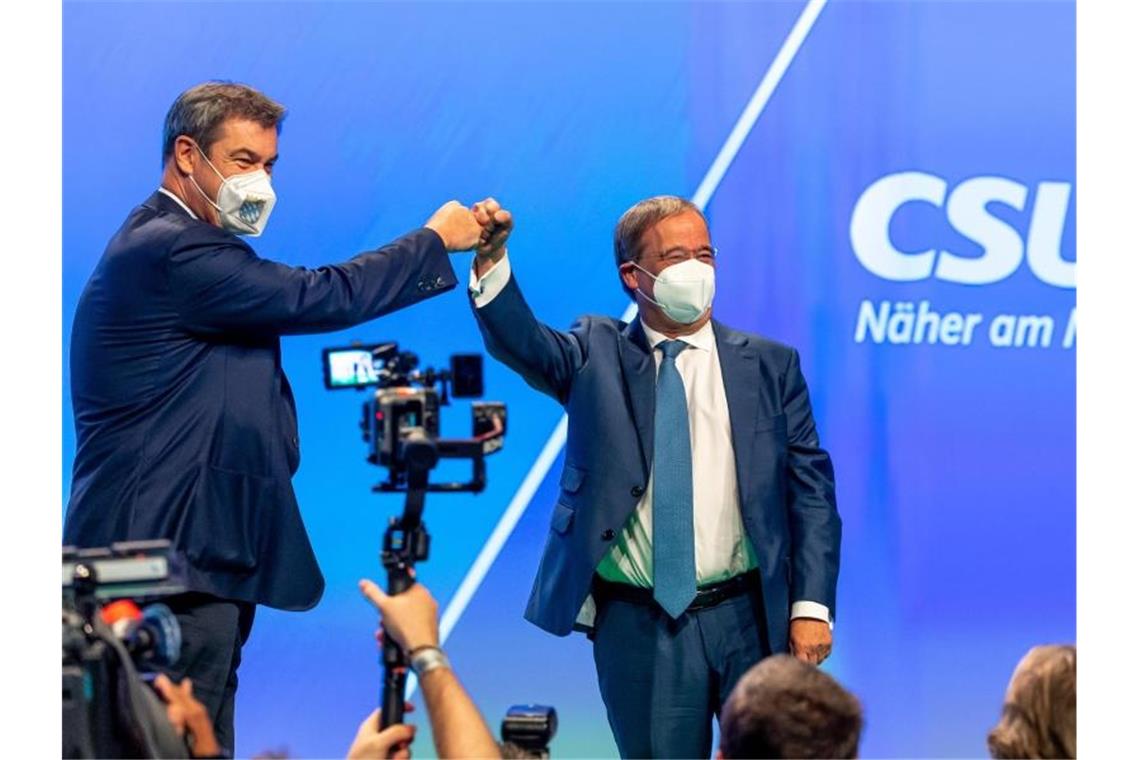 Markus Söder (l), CSU-Parteivorsitzender und Ministerpräsident von Bayern, und Armin Laschet, Unions-Kanzlerkandidat und CDU-Vorsitzender, stehen beim Parteitag der CSU gemeinsam auf der Bühne. Foto: Peter Kneffel/dpa