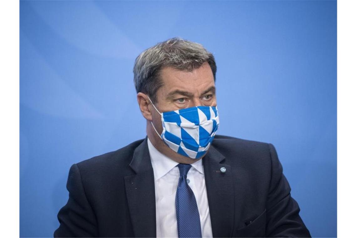 Markus Söder trägt während einer Pressekonferenz einen Mund-Nasen-Schutz. Foto: Stefanie Loos/AFP POOL/dpa