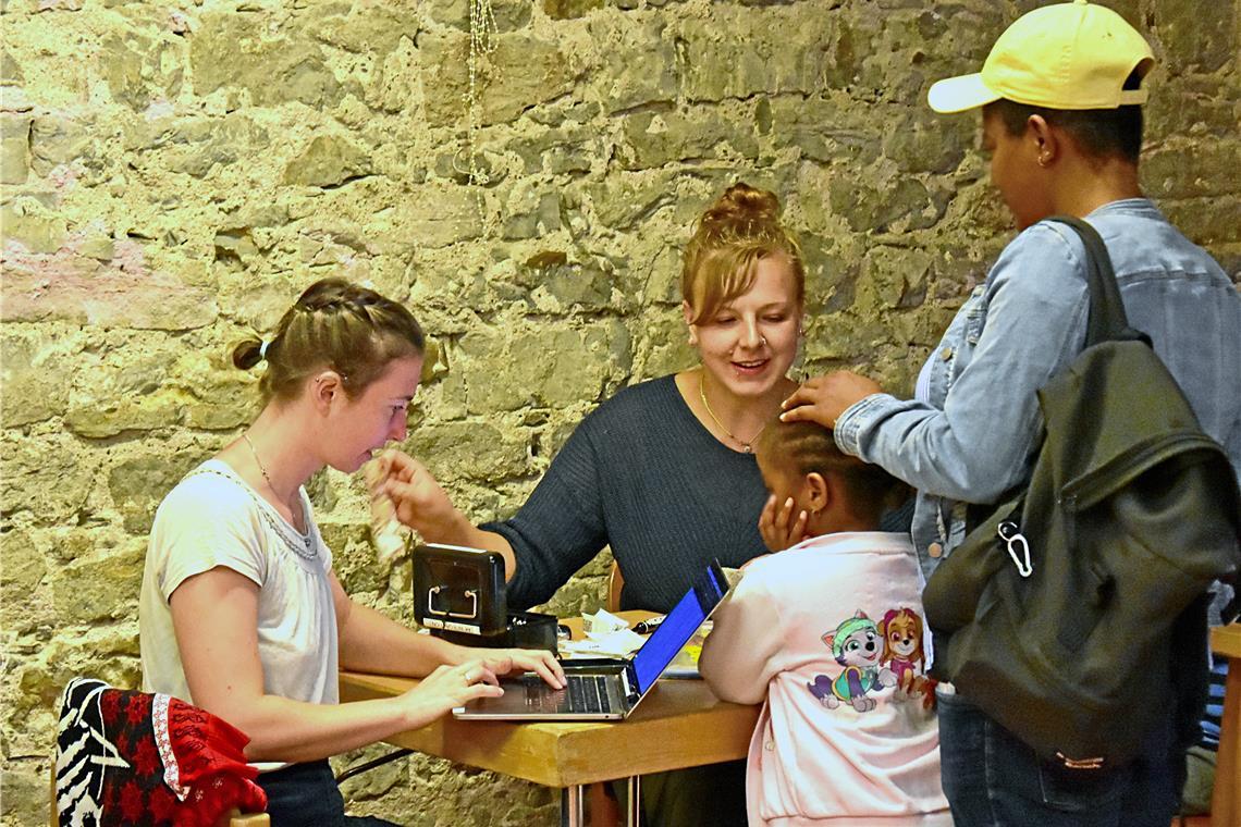 Tauschaktion für Geflüchtete trotzt der Bezahlkarte Marleen Krysl (links) und Ulrike Oesterle (Mitte) sind ehrenamtlich für die Awo tätig. Sie nehmen die Gutscheine der Geflüchteten entgegen und zahlen ihnen deren Gegenwert in bar aus. Foto: Tobias Sellmaier