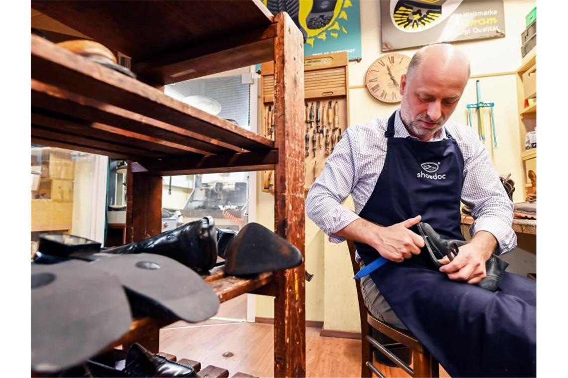 Martin Stoya von der Firma shoedoc arbeitet an einem Schuh eines Flutopfers. Foto: Uli Deck/dpa/Archivbild