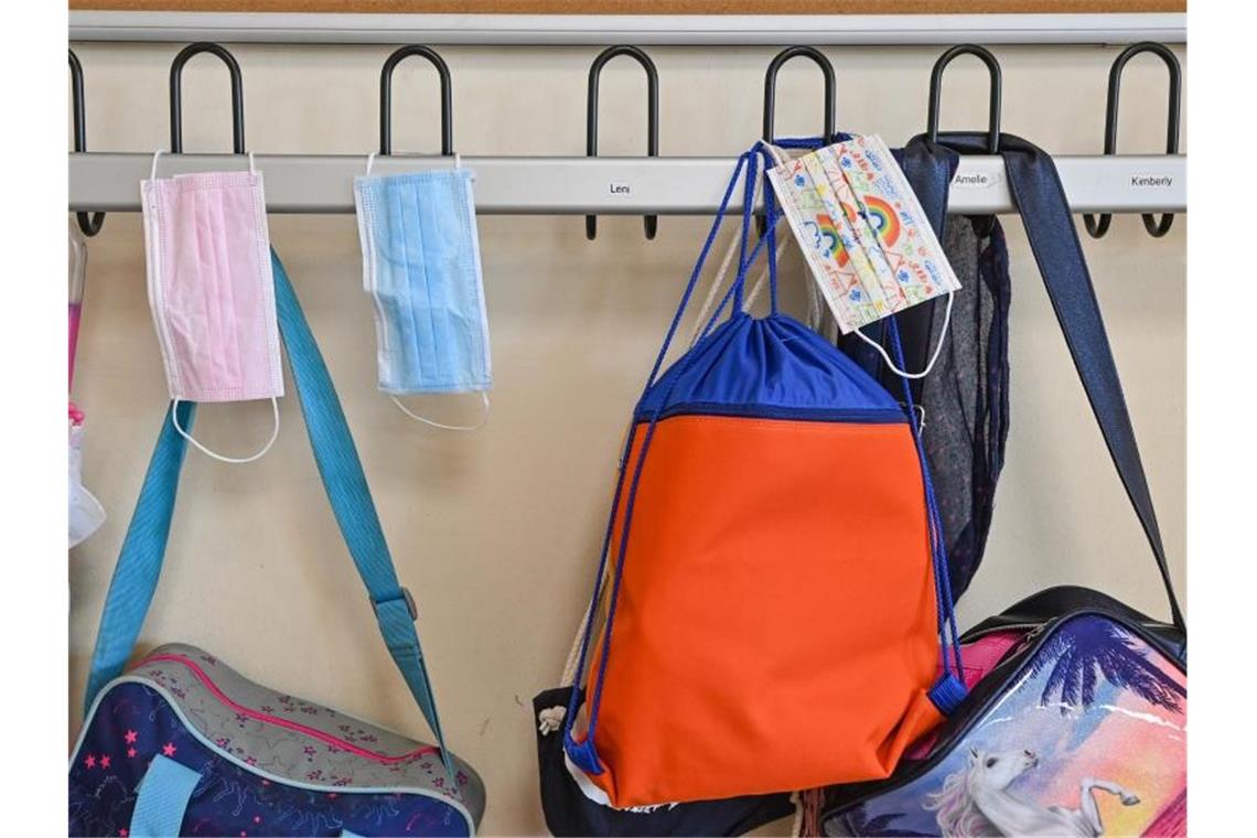 Länder lockern Regeln - Debatte über Masken an Schulen Masken hängen zusammen mit Taschen und Rucksäcken an Kleiderhaken in einem Klassenraum einer Grundschule. (Archivbild). Foto: Patrick Pleul/dpa-Zentralbild/dpa