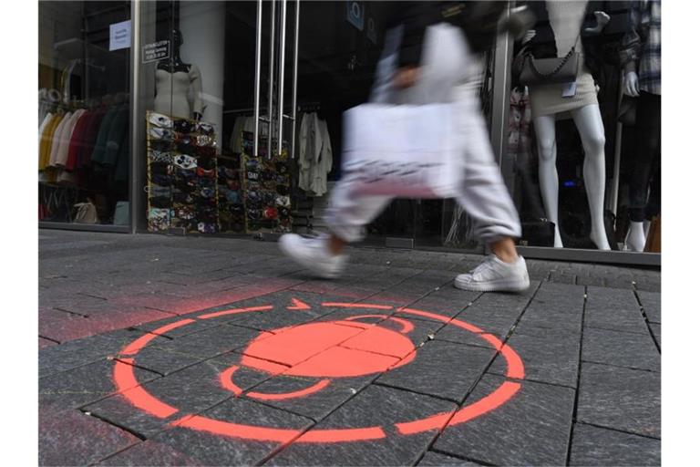 Masken-Symbol in einer Kölner Einkaufsstraße. Corona und der für den November verhängte Teil-Lockdown sorgen ausgerechnet im wichtigen Weihnachtsgeschäft für leere Innenstädte. Foto: Roberto Pfeil/dpa