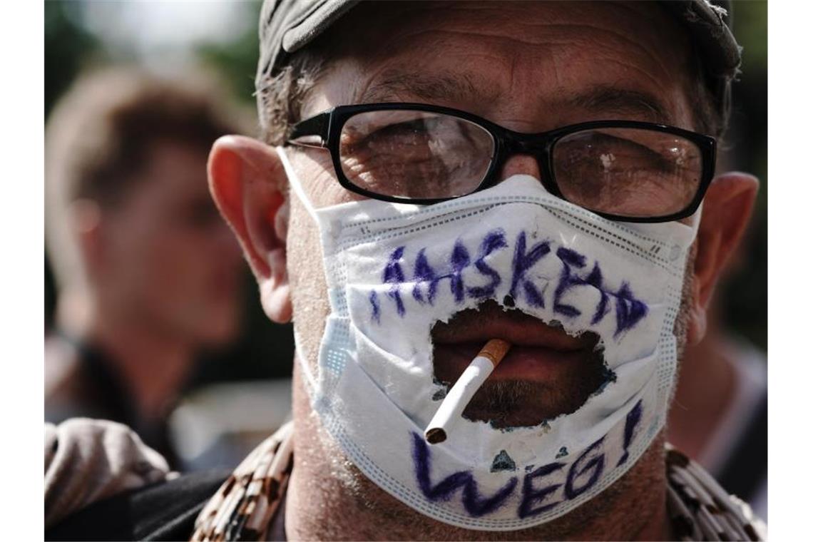 „Masken Weg!“ steht auf dem „Mundschutz“ eines Teilnehmers einer Demonstration gegen die Corona-Maßnahmen. Künftig wird es zur Pflicht, auf Demonstrationen in Berlin Masken zu tragen. Foto: Michael Kappeler/dpa