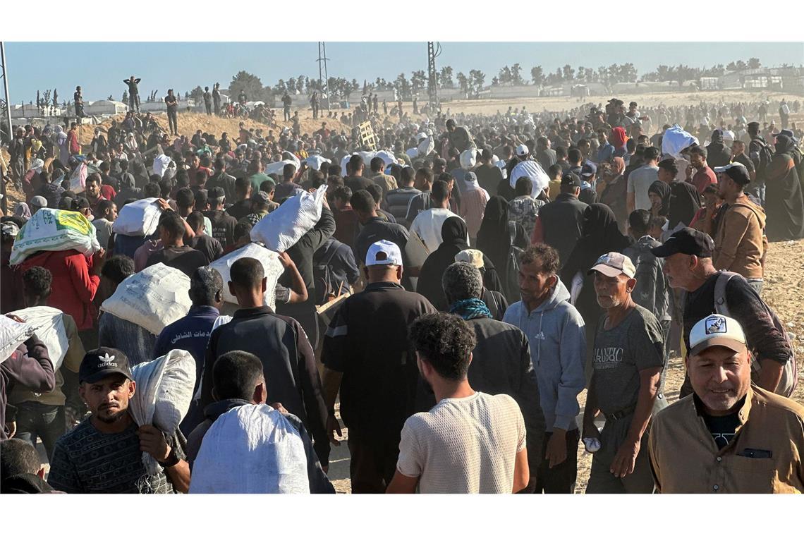 Bilder des Tages Massen von Palästinensern tragen in der Nähe von Gaza Hilfsgüter, einige tragen Kisten und Taschen auf dem Kopf.