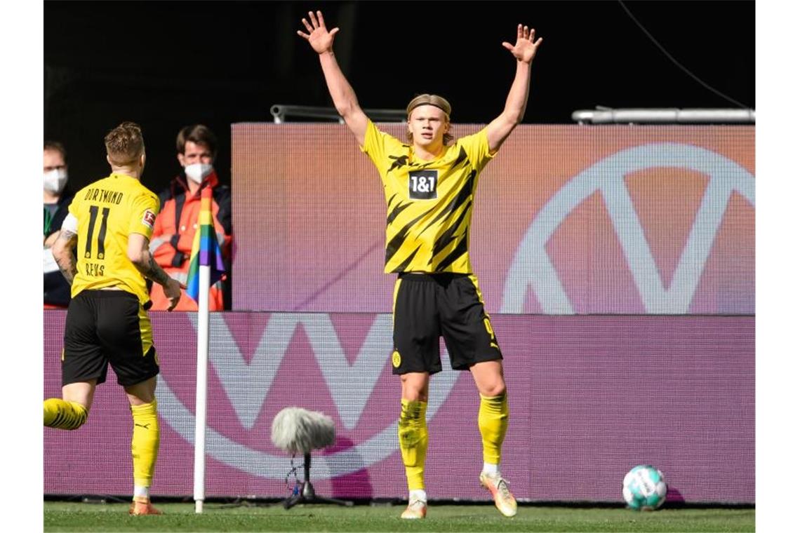 Matchwinner Erling Haaland (r) wird von BVB-Teamkollege Marco Reus in Wolfsburg gefeiert. Foto: Swen Pförtner/dpa