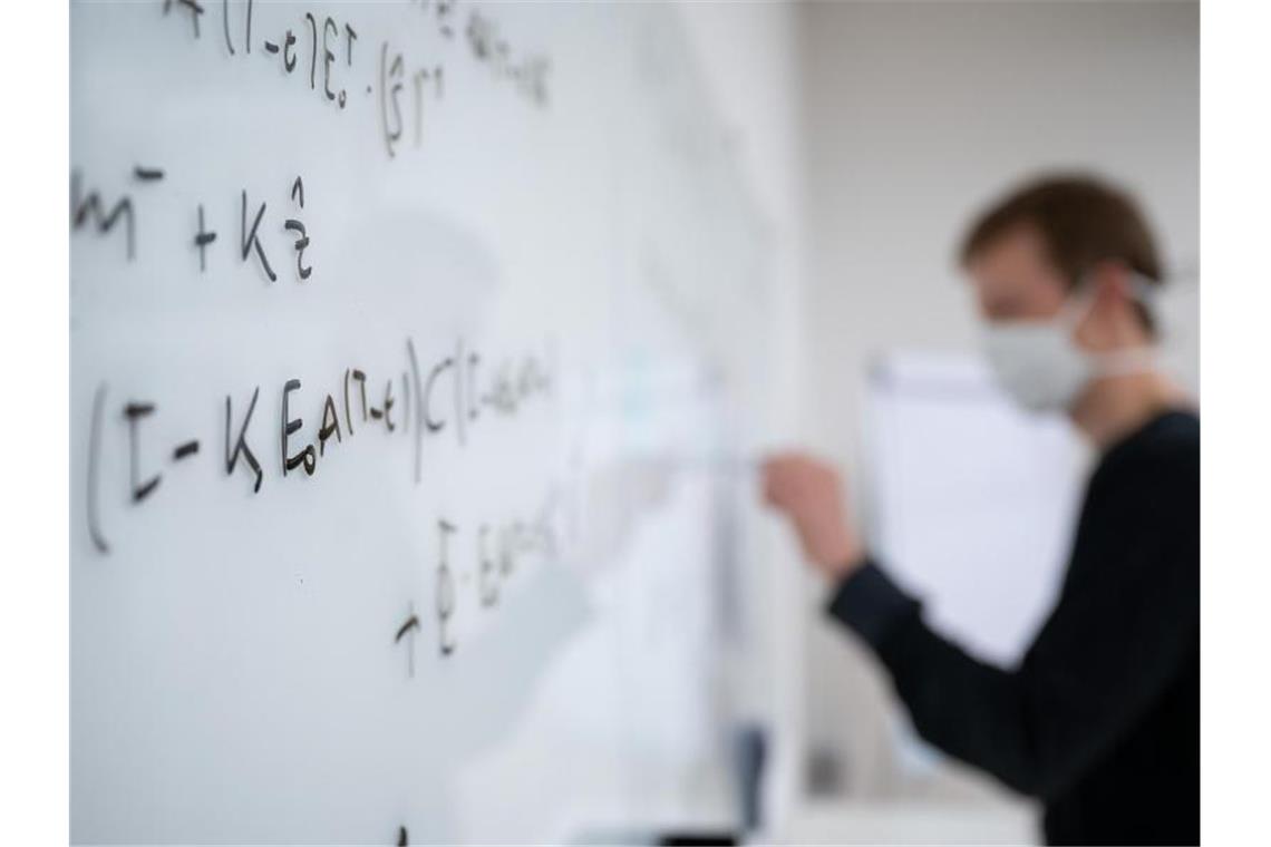 Mathematische Formeln werden in der Universität Tübingen an ein Whiteboard geschrieben. Foto: Sebastian Gollnow/dpa/Symbolbild