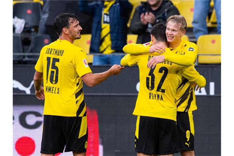 Mats Hummels (l) feiert mit dem Giovanni Reyna (32) umarmenden Erling Haaland einen Treffer im Spiel gegen den SC Freiburg. Foto: Guido Kirchner/dpa