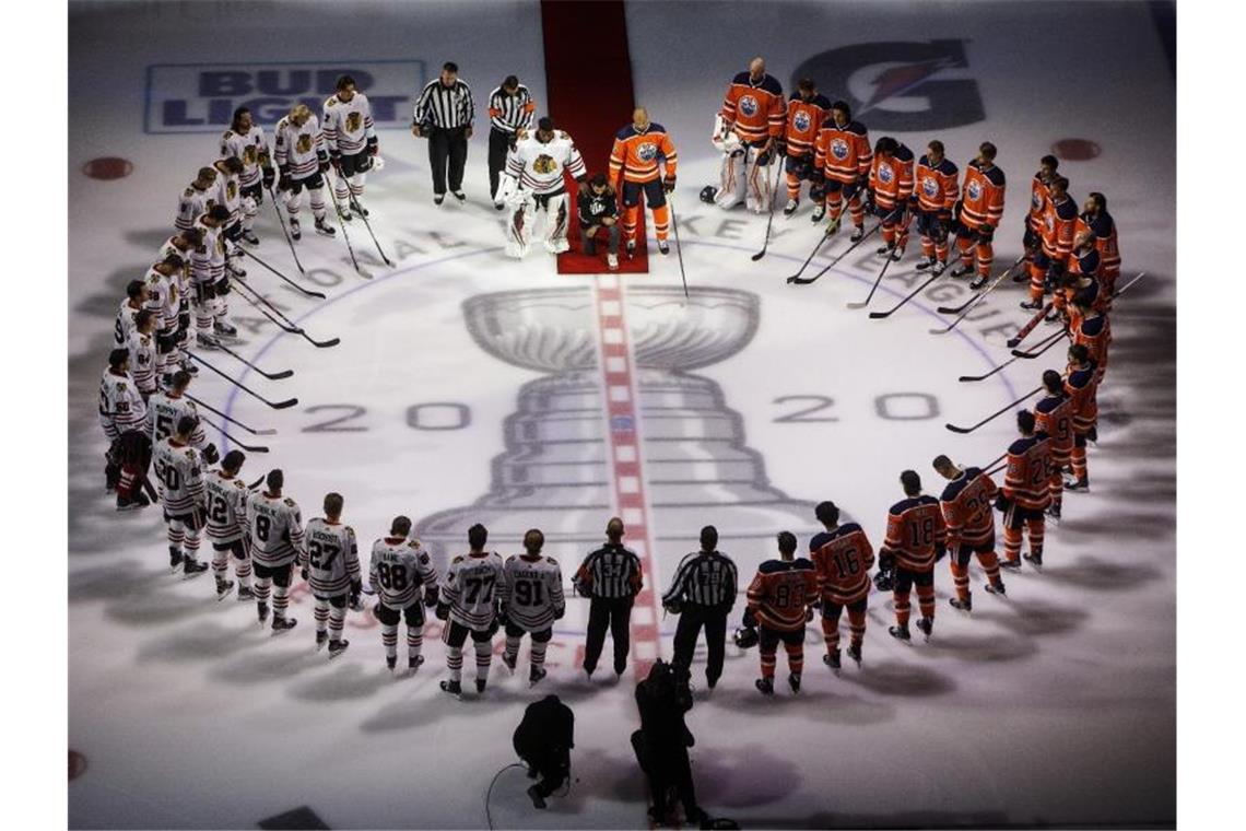 NHL-Re-Start: Politischer Note und starker Draisaitl Matt Dumba (M) von Minnesota Wild kniet während der Nationalhymne vor dem NHL-Restart. Foto: Jason Franson/The Canadian Press/AP/dpa