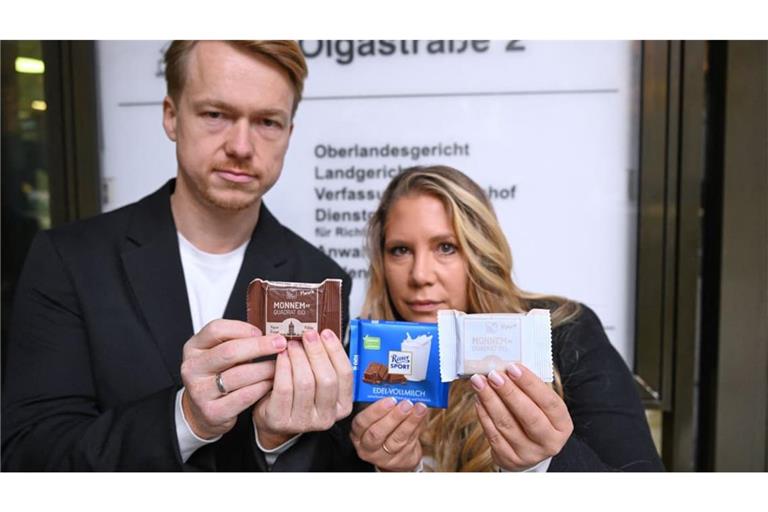 Matteo (l) und Melanie Wacker (r), die Betreiber der Firma Wacker, halten vor dem Oberlandesgericht Riegel der Firma Wacker und eine Ritter Sport Schokolade in den Händen. Ritter Sport sieht durch einen quadratischen Riegel der Mannheimer Firma Wacker seine Marke verletzt und klagt. Vor dem Landgericht kassierte Ritter Sport im November 2025 eine Schlappe. Nun verhandelt das Oberlandesgericht über die Berufung von Ritter Sport.