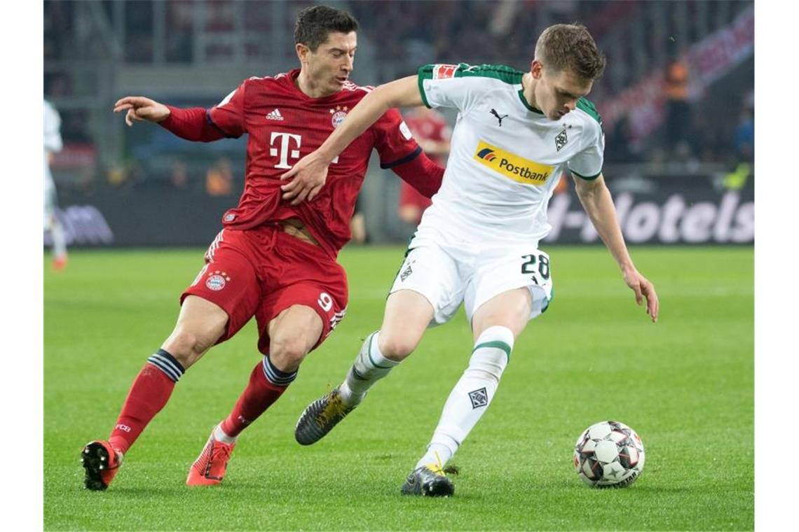 Matthias Ginter (r) erwartet mit Gladbach Robert Lewandowski mit dem FC Bayern zum Liga-Gipfel. Foto: Federico Gambarini/dpa