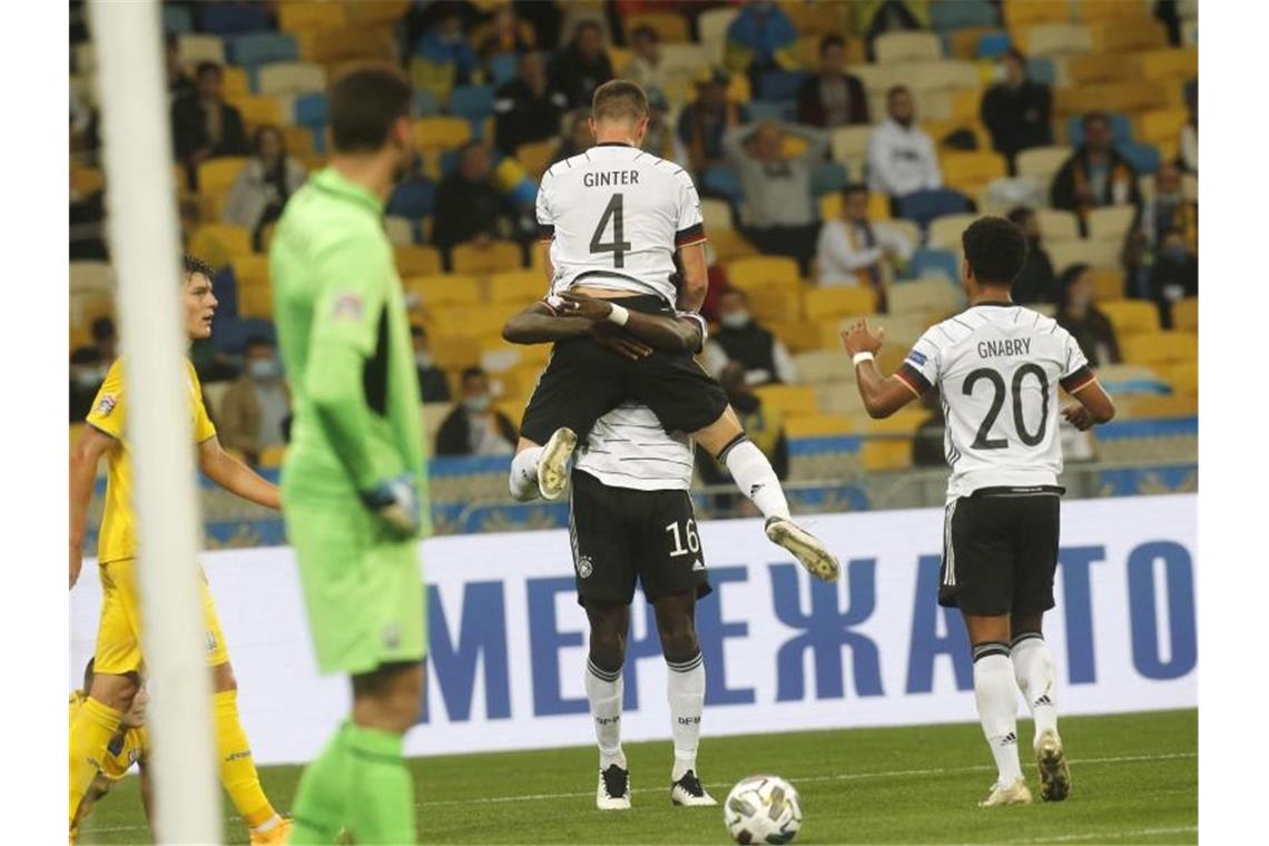 Endlich wieder ein Sieg: Löws A-Team gewinnt in Kiew Matthias Ginter, Torschütze zum 1:0, wird von Mannschaftskamerad Antonio Rüdiger beim jubeln hochgehoben - Serge Gnabry kommt zum feiern dazu. Foto: Efrem Lukatsky/AP/dpa