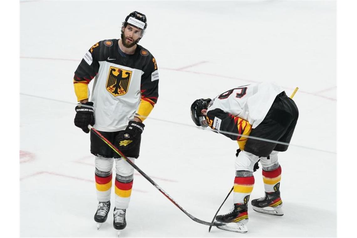 Matthias Plachta (l) und Marcel Noebels stehen nach einem Spiel auf dem Eis. Foto: Roman Koksarov/dpa/Archivbild